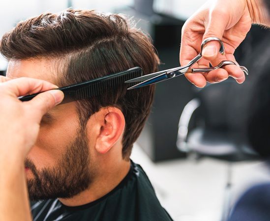 Persona cortando cabello de hombre